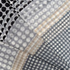 Close-up Margo Selby monochrome polka dot wool scarf, highlighting its texture and detailed pattern.